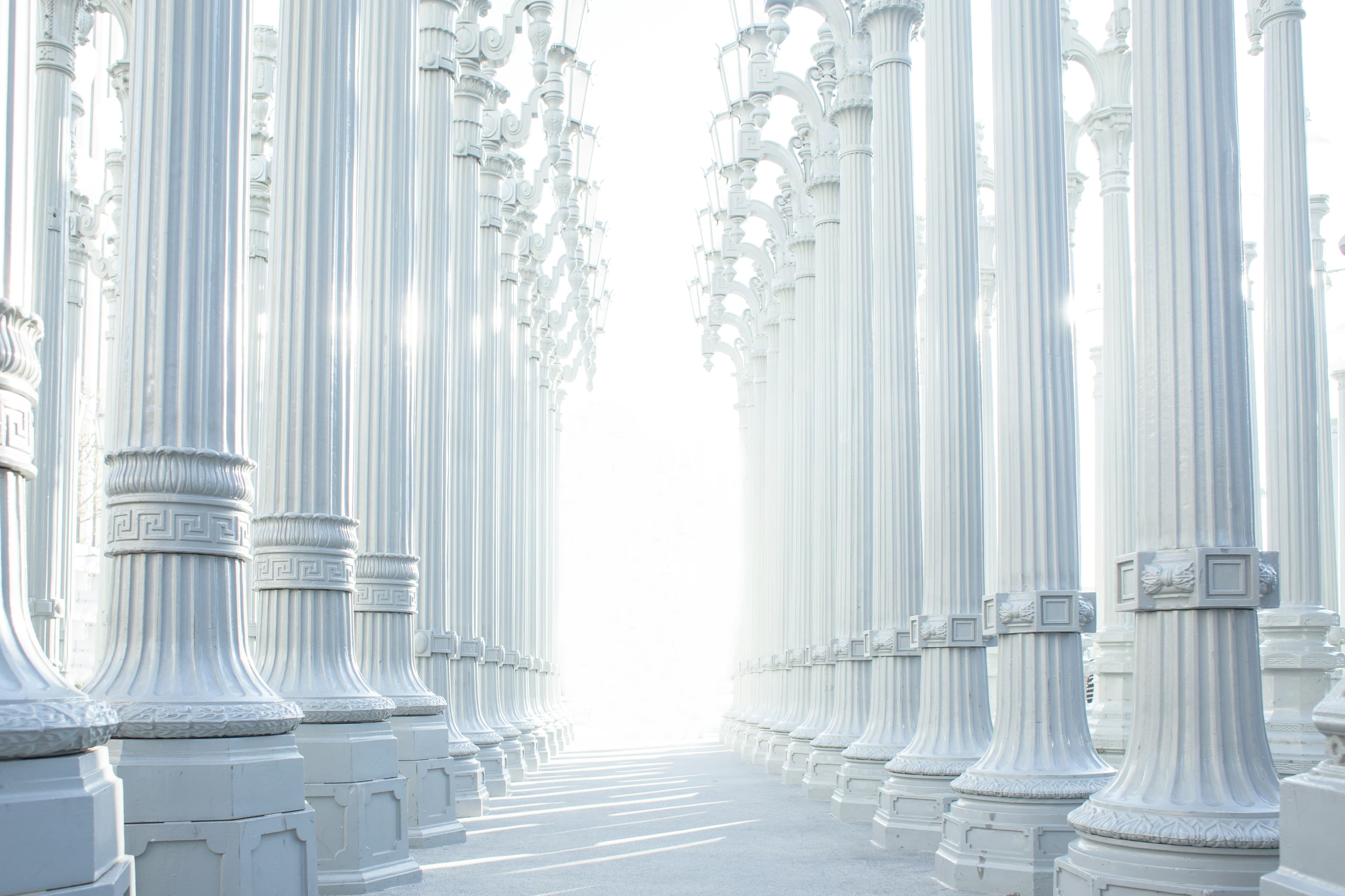 Rows of white columns leading toward bright light
